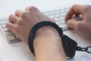 hand in cuffs by a keyboard