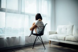 girl sat on chair looking out of window